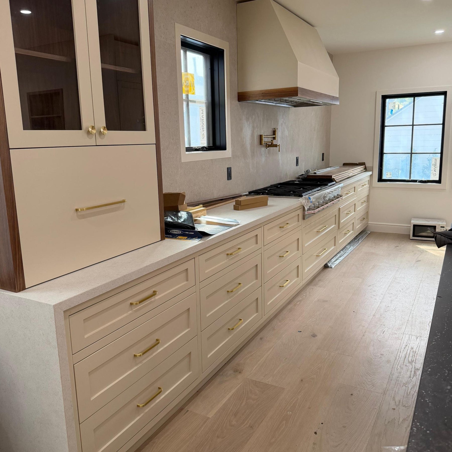 Modern kitchen with beige cabinets, white countertops, and stainless steel appliances.